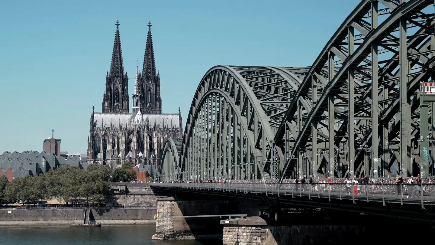 Köln, Dom und Hohenzollernbrücke bei klarem Himmel.